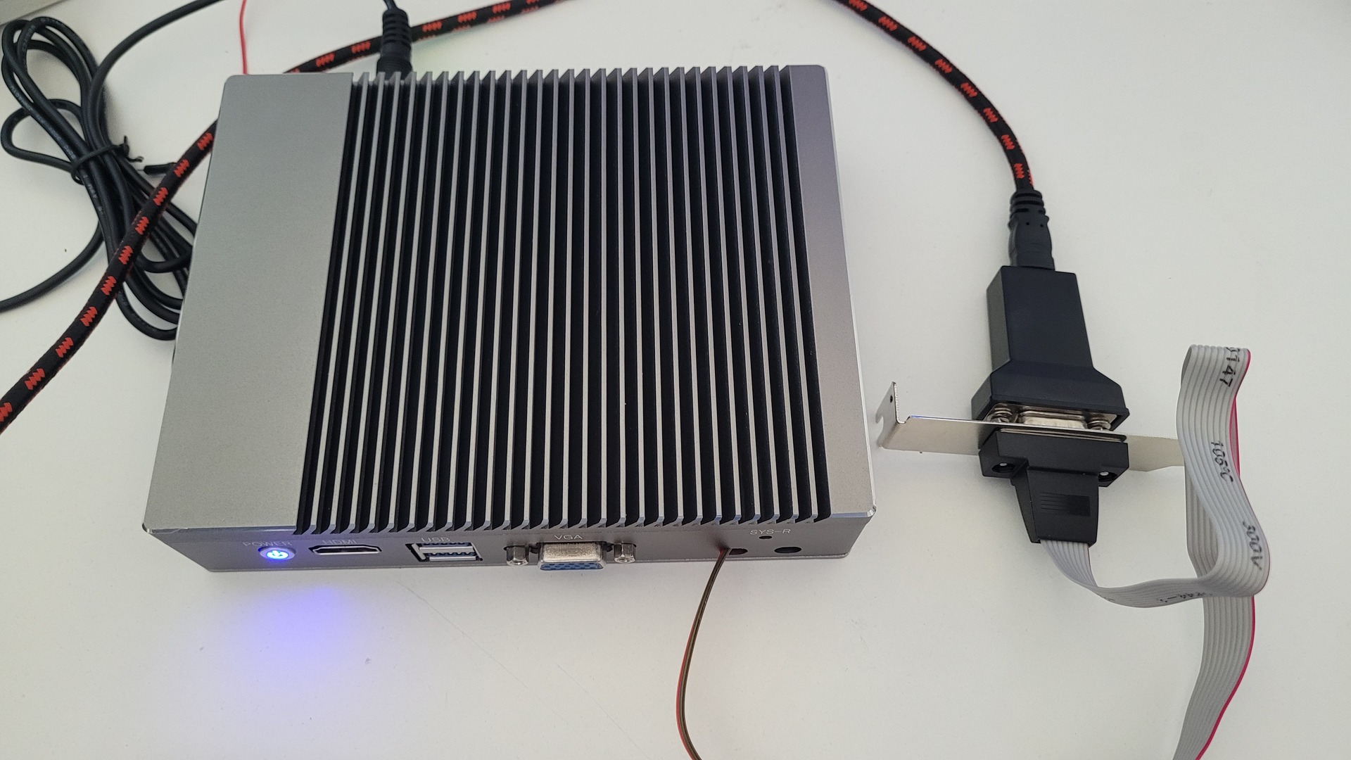 Fanless mini PC connected to a USB-to-serial adapter